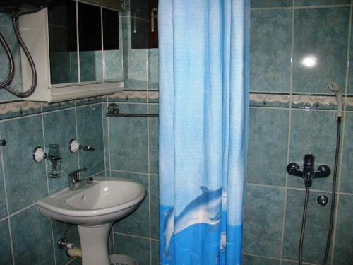 扎布利亚克MB酒店的浴室设有水槽和蓝色的浴帘
