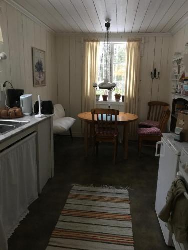 ForshagaLillemyrsgården的厨房以及带桌椅的用餐室。