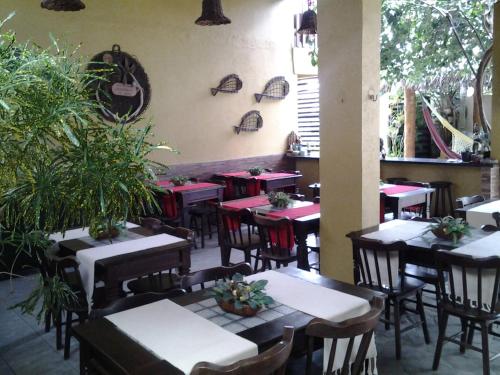 卢塞纳Pousada Lazer do Sol的植物间里带桌椅的餐厅