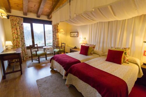 贝拉新镇兰诺蒂内奥酒店的一间卧室设有两张床、一张桌子和窗户。
