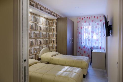 维克艾库塞Casa Micla的带三张床和书架的房间