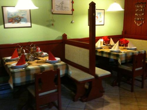 莫雄马扎尔古堡莫特奈特T酒店的一间用餐室,配有两张红色帽子的桌子