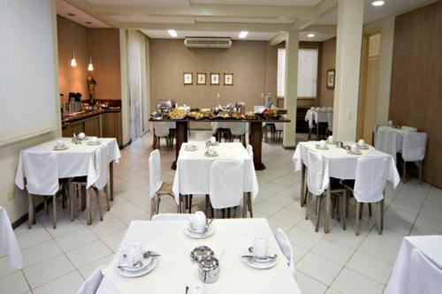 NaviraíHotel 2 Gauchos的用餐室配有白色的桌子和白色的椅子