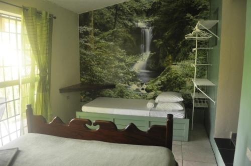 SalybiaLeatherback Lodge Eco B&B的卧室的墙上挂有瀑布壁画