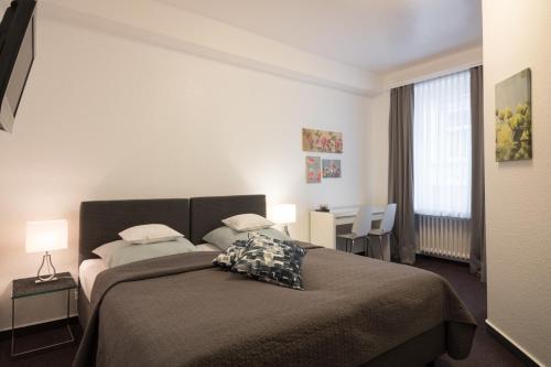 科隆布瑞登伯格酒店的一间卧室配有一张床、一张书桌和一个窗户。