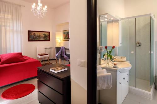 罗马罗马市中心旅馆的浴室设有红色的床、水槽和镜子