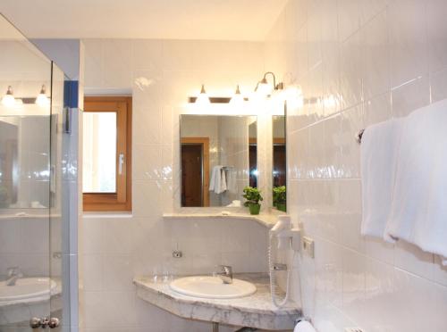 斯泰尔维奥嘉利亚酒店的白色的浴室设有两个盥洗盆和镜子
