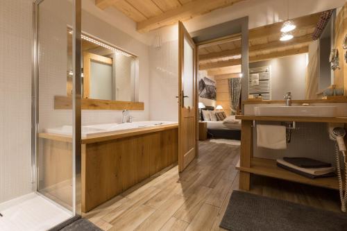扎科帕内斑比公寓式酒店的带浴缸、水槽和镜子的浴室