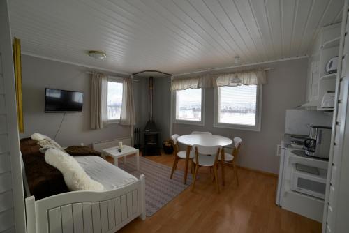 基尔匹斯扎我维Guesthouse Haltinmaa的一间卧室配有一张床铺和一张桌子,还设有一间厨房
