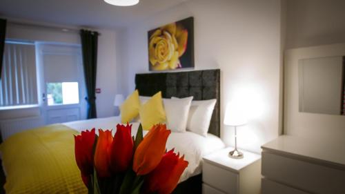 伯明翰UR City Pad - Richmond Apartments的一间卧室,配有一张带一束红花的床