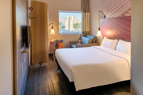 圣贝尔纳多-杜坎普ibis Sao Bernardo do Campo的酒店客房设有一张白色大床和一个窗户。