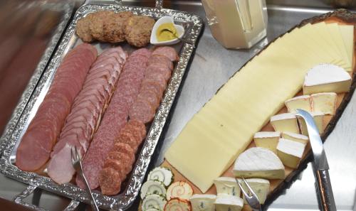 根廷Hotel Grüner Baum的盘子上放着肉、奶酪和奶酪