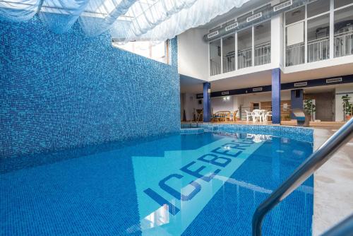 班斯科班斯科冰山酒店的一座建筑物边的蓝色瓷砖游泳池