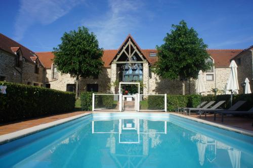 克雷西拉沙佩勒Hotel Les Suites - Domaine de Crécy的大楼前的游泳池