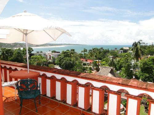 埃斯孔迪多港埃斯孔迪多帕拉伊索酒店的阳台配有桌子和遮阳伞,享有海景。