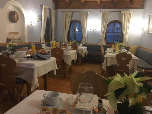 贝格海姆费斯查斯塔本酒店的餐厅设有白色的桌椅和窗户。