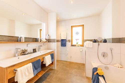 奥伯斯特多夫Casatina Ferienwohnungen的白色的浴室设有浴缸和水槽。
