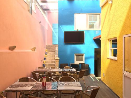 菲盖拉-达福什Meeting Hostel的一间带桌椅的餐厅以及墙上的电视