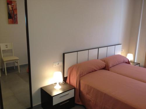 洛帕莞普迪卡旅馆的一间卧室配有两张床和床头灯。