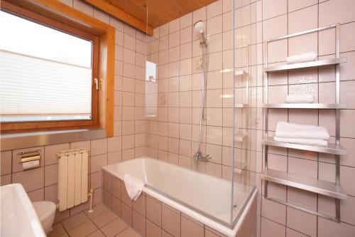 卡普伦Apartments Obernosterer - Großglockner的带浴缸、卫生间和窗户的浴室