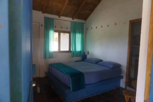洛佩斯港萨菲吉山林小屋的一间卧室配有一张带蓝色床单的床和一扇窗户。
