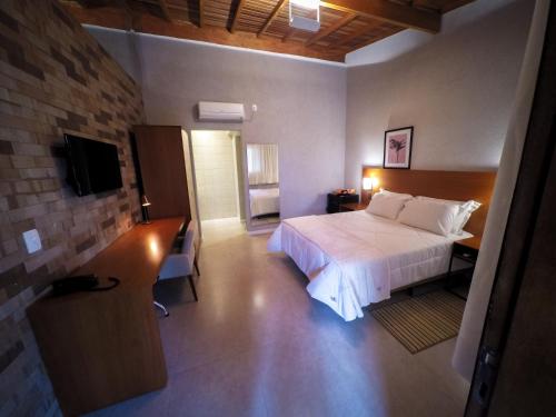 塞拉内格拉Pousada Santa Thereza的酒店客房,配有床和电视