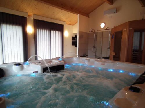 Gavaudun加沃丹葡萄园酒店的浴室内设有一个蓝色灯光按摩浴缸