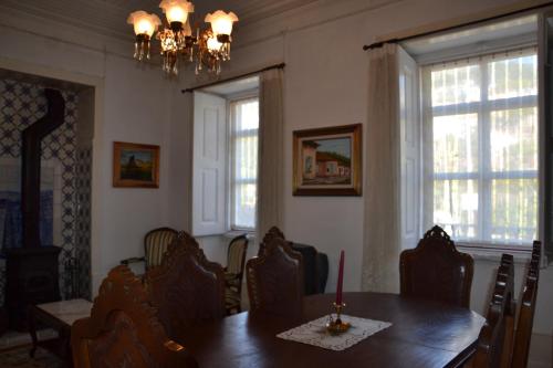 洛里加Casa da Ponte do Arrocho的一间带桌椅和吊灯的用餐室