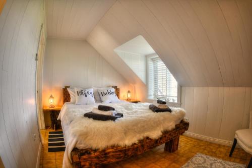 拉马巴耶Les 2 Iles - Les Chalets Spa Canada的阁楼上的卧室配有一张大床