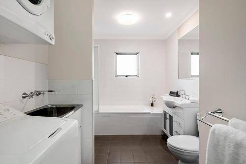 卧龙岗武龙岗探索服务酒店的白色的浴室设有水槽和卫生间。