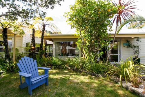 哈海Tatahi Cove Back Packer的坐在房子的院子中的蓝色椅子