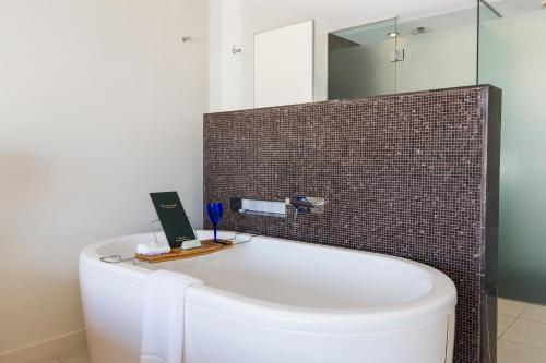 耐莉湾蓝色辣椒酒店的浴室配有浴缸及镜子