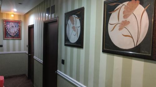 加尔各答布哈马尔纯素食酒店的墙上有两张照片的走廊和一扇门