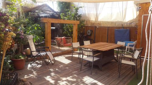 埃拉特Casa Rosa的木制甲板配有木桌和椅子