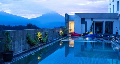 马格朗马格朗阿特里亚酒店的游泳池,晚上可欣赏到山景