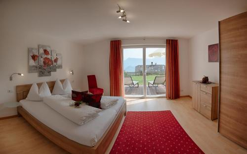 卡尔达罗Residence Prunarhof的一间卧室配有一张床和红色地毯