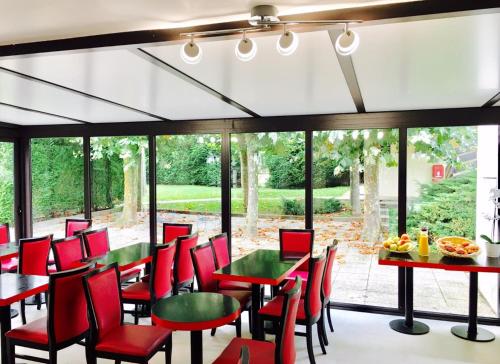 布雷西尔盖缇涅斯阁酒店的餐厅设有红色的椅子和桌子以及窗户。