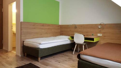 弗莱堡鲁艾 - 禁烟旅馆的一间卧室配有两张床、一张桌子和一把椅子