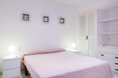 塔马留Ancora的一间白色卧室,配有一张床和两盏灯