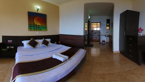 兰斯顿Kasang Regency Hill Resort的一间大卧室,配有两张带白色床单的床