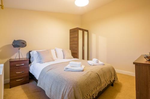 斯蒂夫尼奇Skyline Serviced Apartments - Colestrete的一间卧室配有带毛巾的床