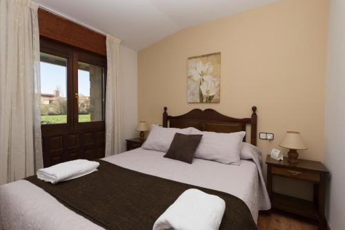 比努埃萨圣伊内斯乡村酒店 的一间卧室配有一张带白色床单的床和一扇窗户。