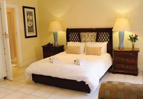 德班Sica's Guest House Musgrave的一间卧室配有一张大床和两条毛巾