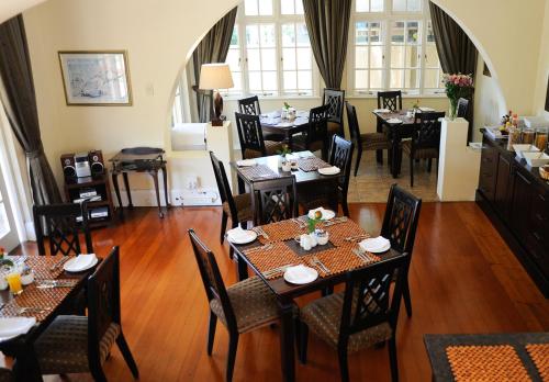 德班Sica's Guest House Musgrave的一间在房间内配有桌椅的餐厅