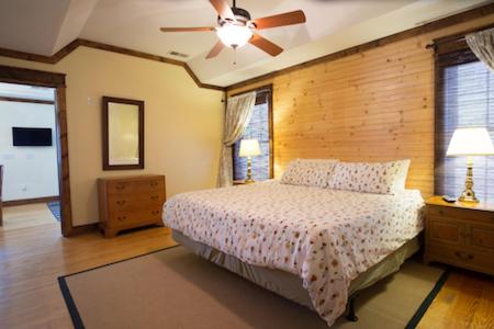 特拉弗勒斯雷斯特Swamp Rabbit Inn Travelers Rest的一间卧室配有一张床和吊扇