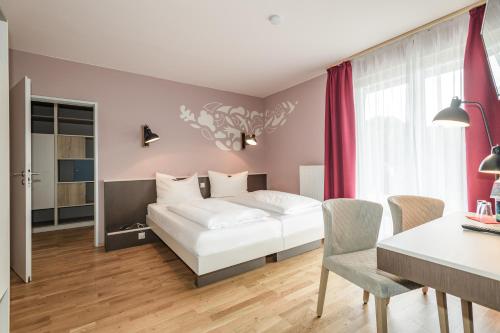 柯尼希斯温特克尼格斯温特／伯恩JUFA酒店的卧室配有白色的床和桌椅