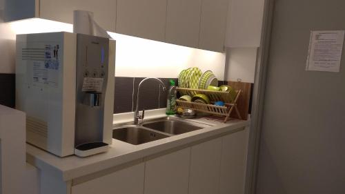 新山INFA@新山赛罗亚公寓的厨房配有水槽和微波炉