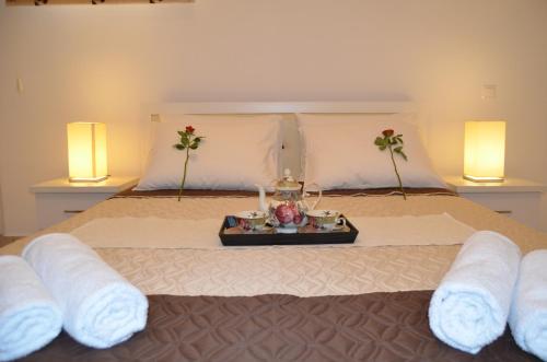 帕拉马Achillion Luxury Corfu Villa的一间卧室配有一张床,上面放着一个食物托盘