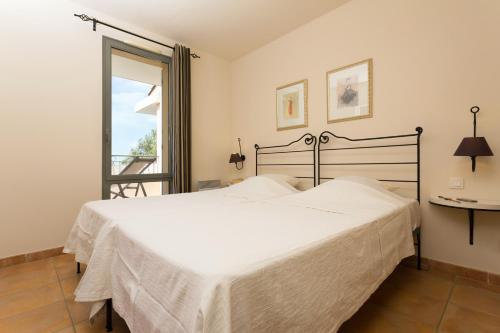 索马讷-德沃克吕兹Madame Vacances Domaine du Provence Country Club Service Premium的卧室设有一张白色大床和一扇窗户。