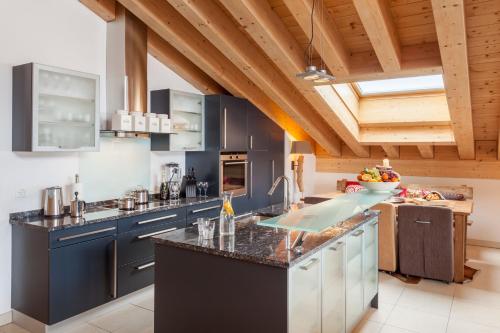 采尔马特Vrony Apartments by Hotel Walliserhof Zermatt的厨房配有蓝色橱柜和台面